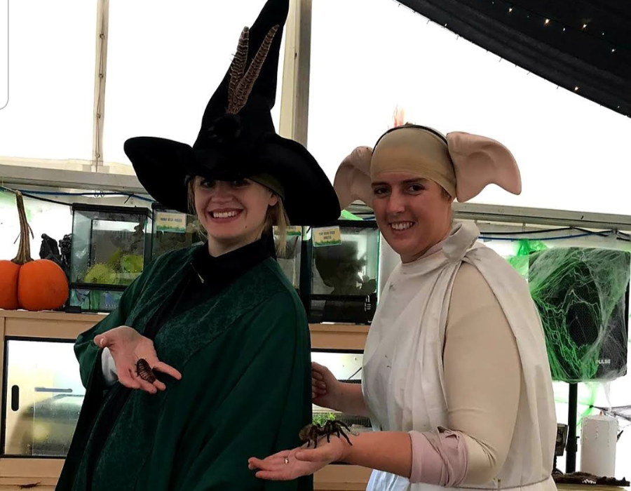 Two women dressed for Halloween event in Derby, one as a witch with green clock and big black hat and the other one as an elf with big ears and white costume